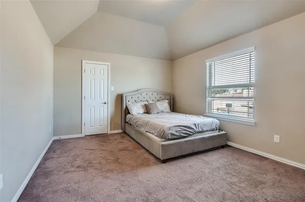 a spacious bedroom with a bed and a window