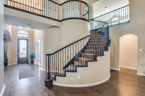 a view of staircase with lots of frames on wall and wooden floor