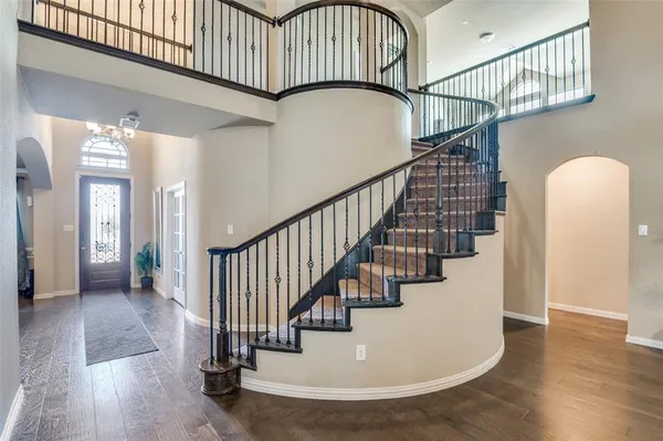 a view of staircase with lots of frames on wall and wooden floor