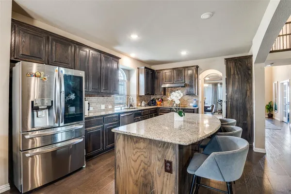 a kitchen with stainless steel appliances granite countertop a refrigerator a sink and a stove