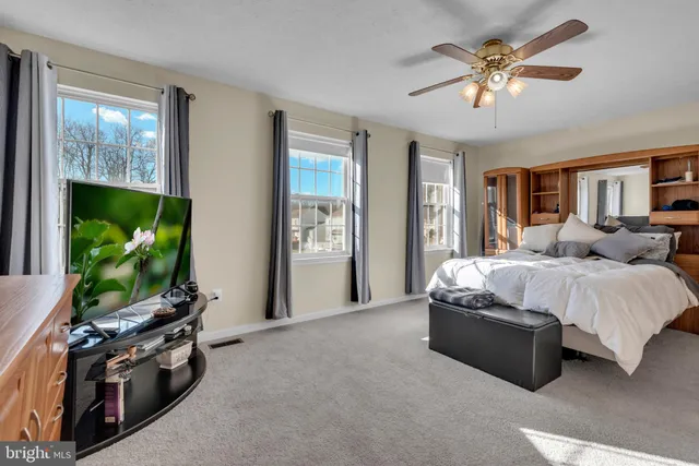 a spacious bedroom with a bed and a flat screen tv