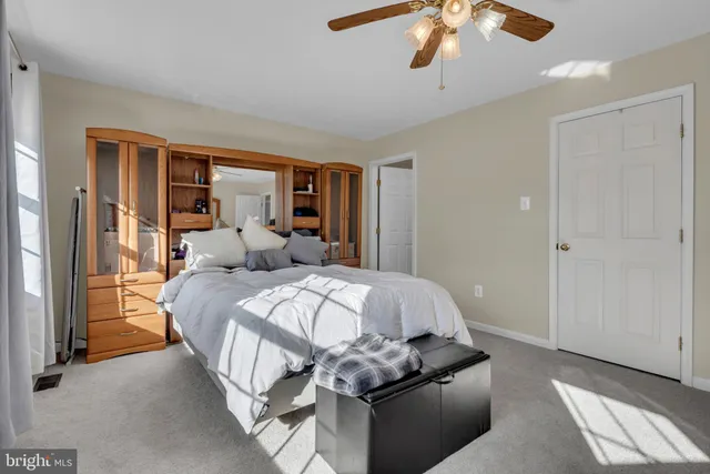 a bed sitting in a bedroom next to a window and a chandelier