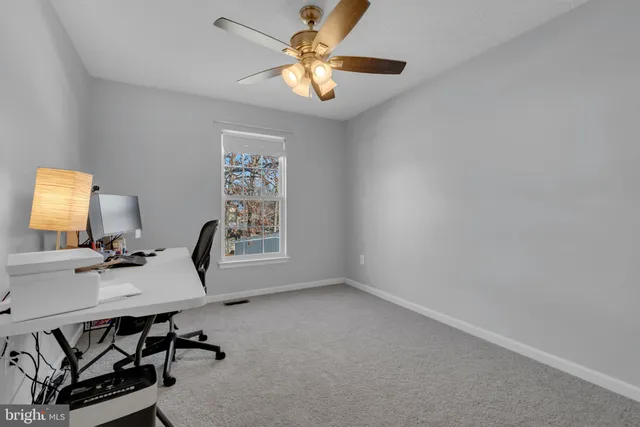 a view of a workspace with furniture and a window