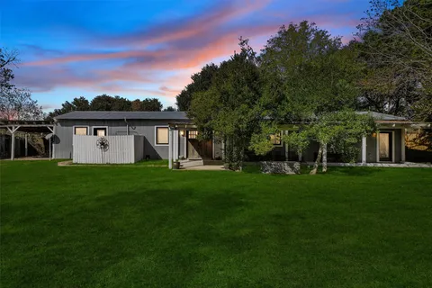 a view of a big house with a big yard and potted plants
