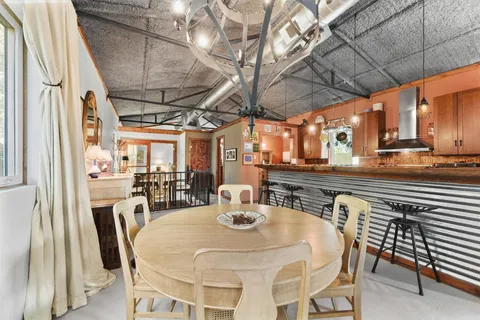 a kitchen with a table chairs and wooden floor