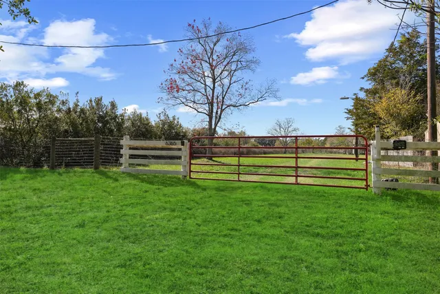 a view of a yard with wooden fence