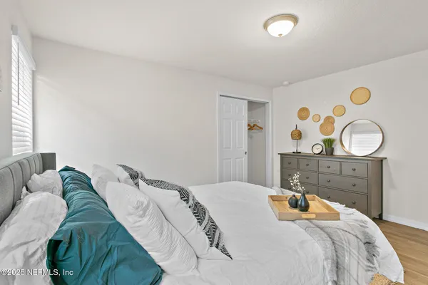 a bedroom with a bed and painting on the wall