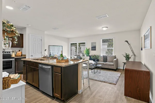 a view of a living room kitchen and a sink