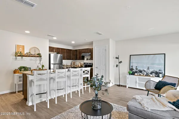 a living room with furniture and a wooden floor