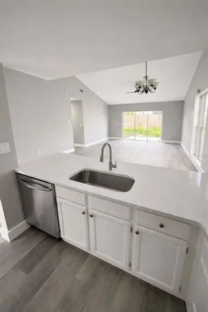 a kitchen with white cabinets a sink and dishwasher