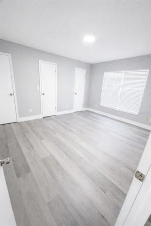 a view of an empty room with wooden floor
