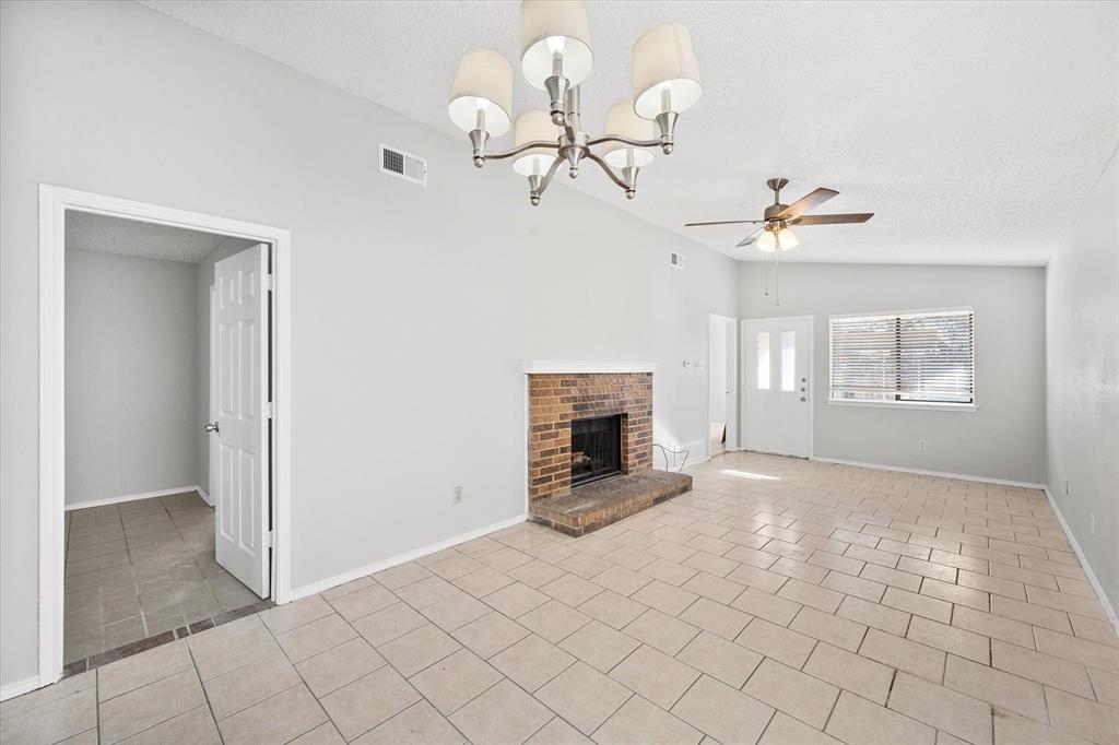 5821 Mansfield Road Arlington, TX 76017 - Photo 7 of 24 a view of a livingroom with a fireplace a chandelier fan and windows