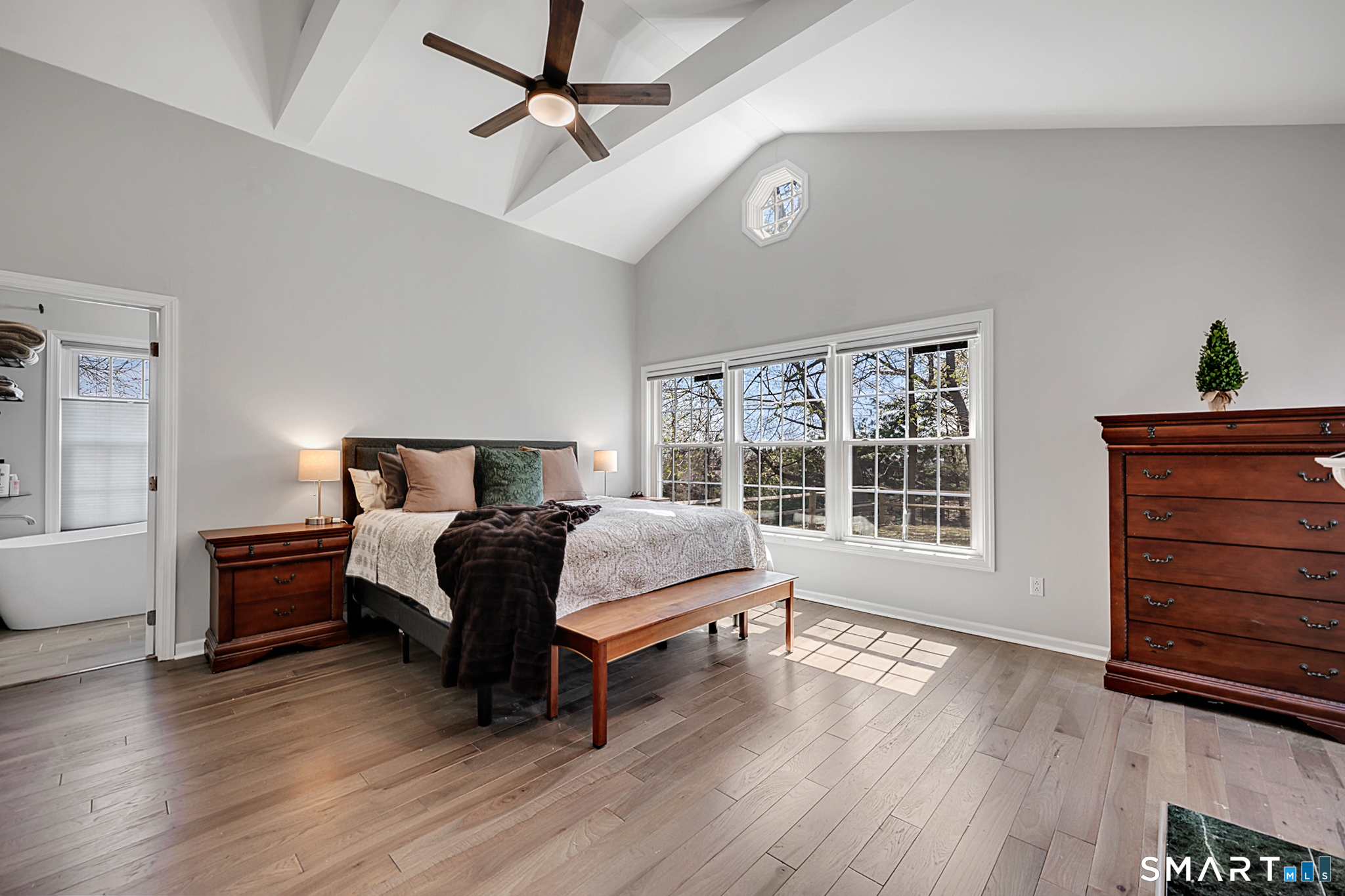 273 Osborne Hill Road Fairfield, CT 06824 - Photo 13 of 40 The Primary Bedroom showcases a vaulted ceiling, beams, a fireplace, three closets, ceiling fan, hardwood floors, and an en-suite.