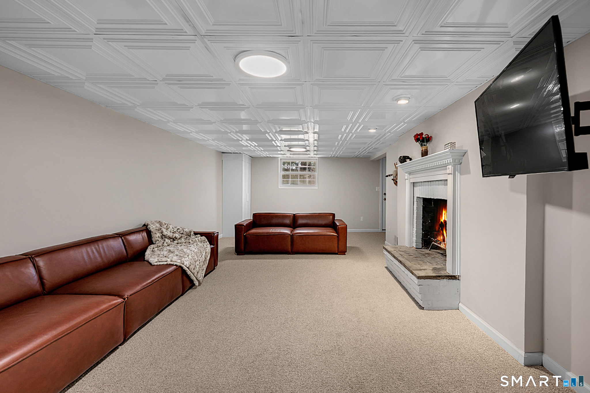 273 Osborne Hill Road Fairfield, CT 06824 - Photo 28 of 40 The Family Room in the lower level has beautiful new carpet and decorative ceiling tiles.