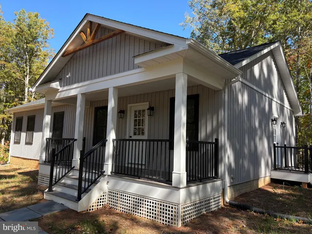 a view of a house with wooden fence and floor to ceiling windows