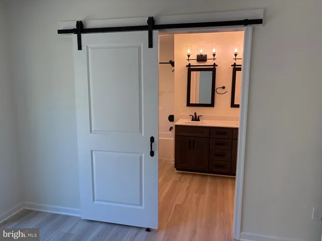 a view of a hallway with wooden floor and front door