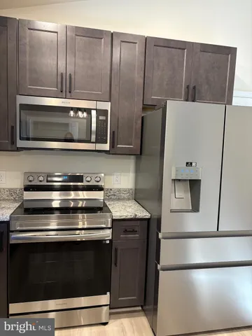 a kitchen with granite countertop a stove and a microwave oven