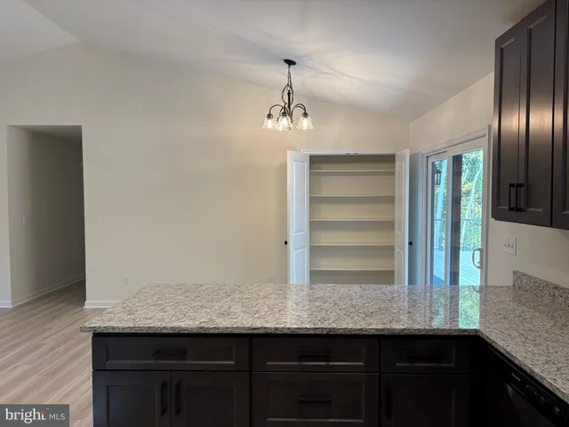 a view of a kitchen with granite countertop stainless steel appliances and wooden floor