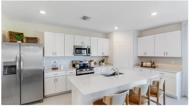 a kitchen with stainless steel appliances cabinets a sink and a refrigerator