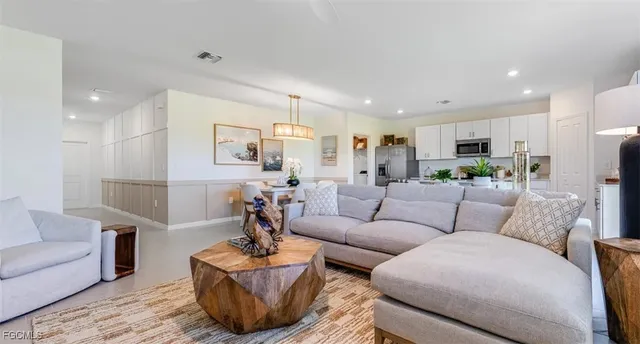a living room with furniture kitchen view and a potted plant