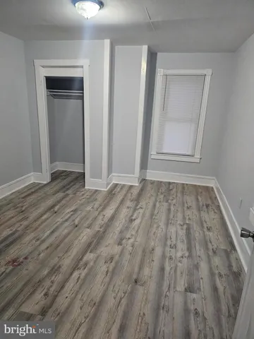 a view of an empty room with closet and a window