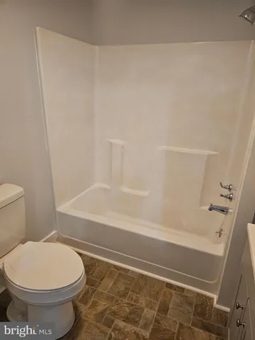 a bathroom with a toilet and a bath tub