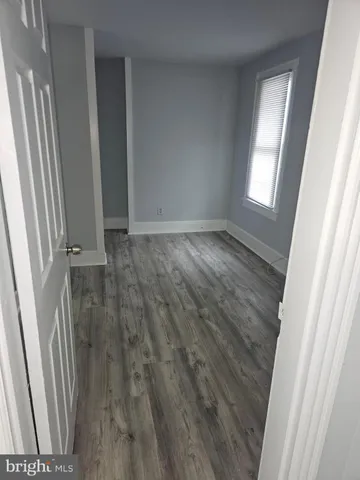 an empty room with wooden floor and a window