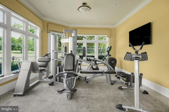 a view of a hallway with wooden floor windows and a living room