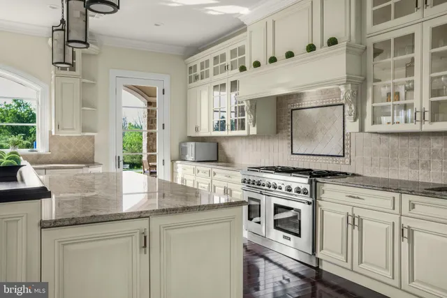 a kitchen with granite countertop white cabinets and window