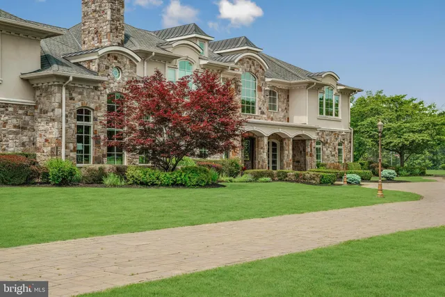 a view of a white house with a big yard and potted plants