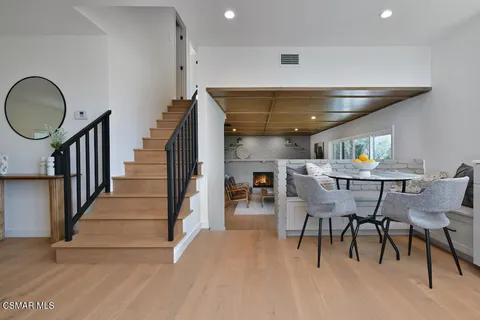 a dining room with furniture potted plants and wooden floor