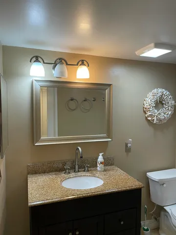a bathroom with a granite countertop sink and a mirror