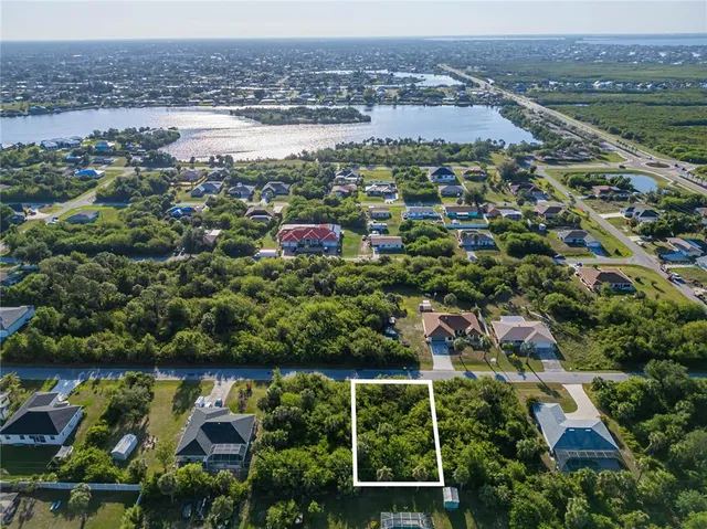 an aerial view of residential houses with outdoor space and trees