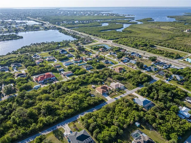 an aerial view of residential houses with outdoor space and trees