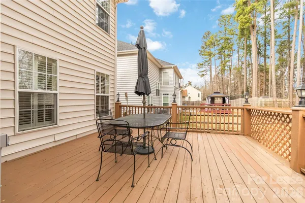 a view of a roof deck with table and chairs with wooden floor and fence