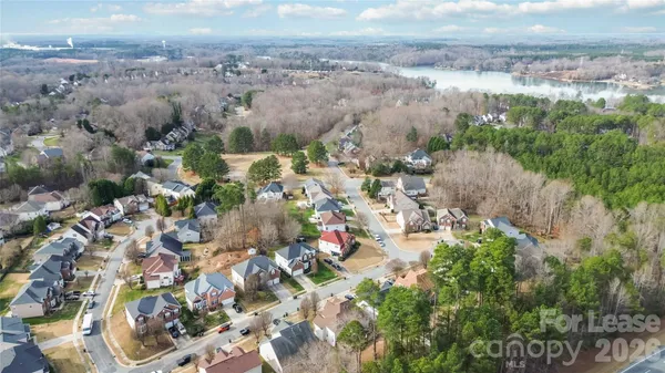 an aerial view of a house with a yard and tree s