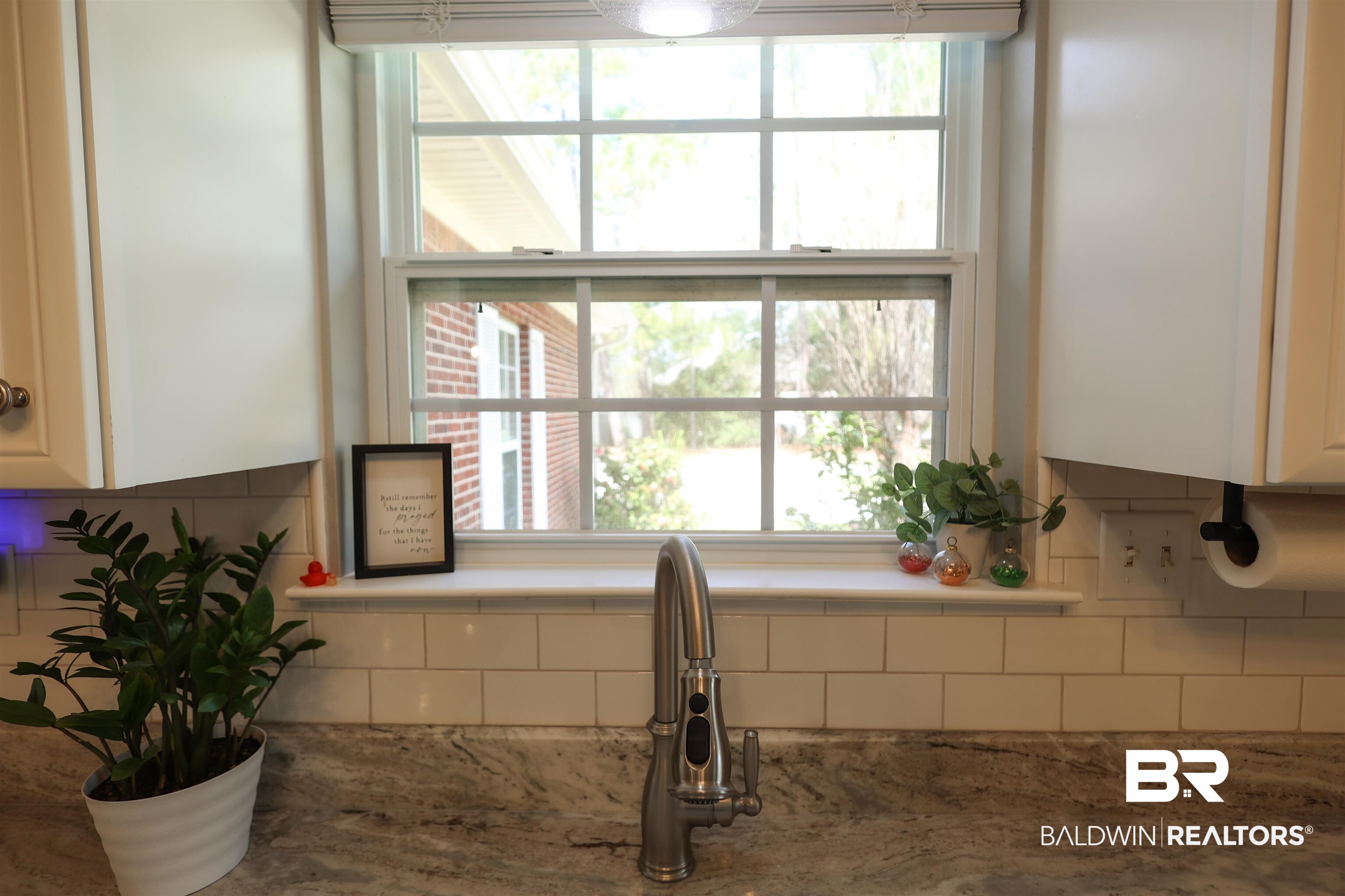 5151 Beatrice Road Gulf Shores, AL 36542 - Photo 18 of 50 Kitchen view of white cabinets, light stone counters, and tasteful backsplash