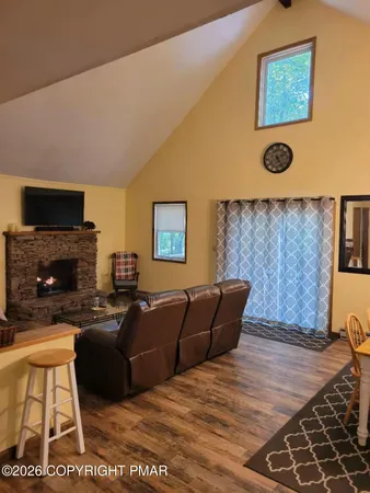 a living room with furniture a flat screen tv and a fireplace
