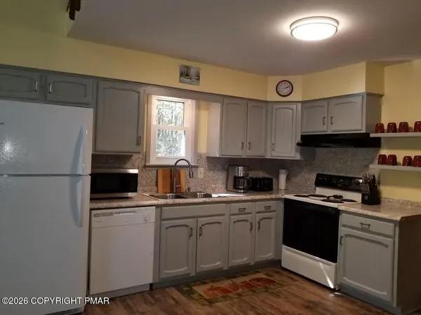 a kitchen with a sink a refrigerator and cabinets