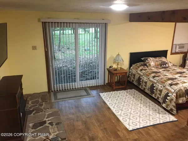 a bedroom with a bed and wooden floor