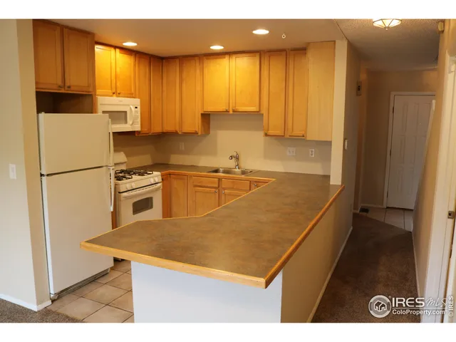 a kitchen with stainless steel appliances granite countertop a refrigerator a sink and a stove
