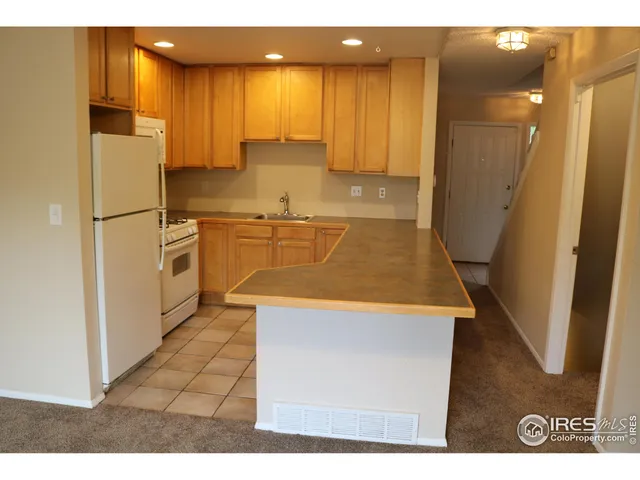 a kitchen with stainless steel appliances granite countertop a refrigerator a stove and a sink