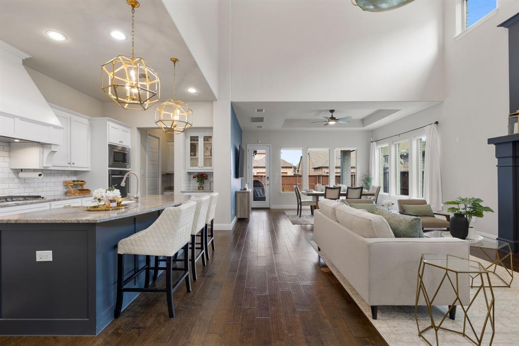 1806 Evening Star Road Frisco, TX 75033 - Photo 10 of 38 Living room featuring dark hardwood / wood-style flooring, ceiling fan with notable chandelier, and a raised ceiling