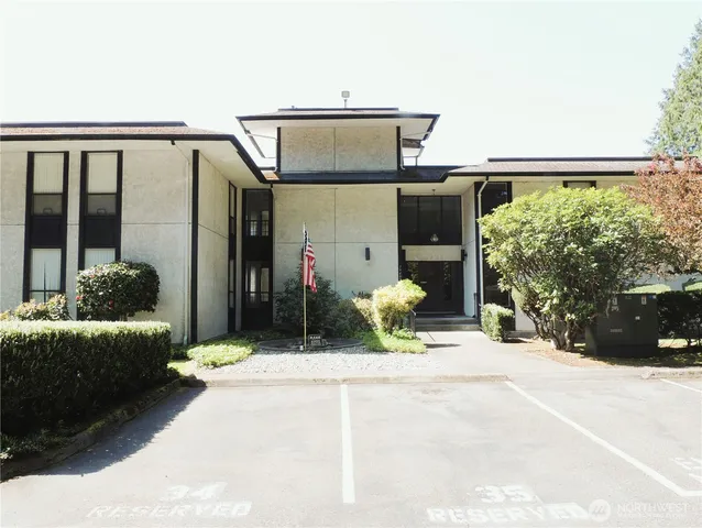 a front view of a house with a yard and trees
