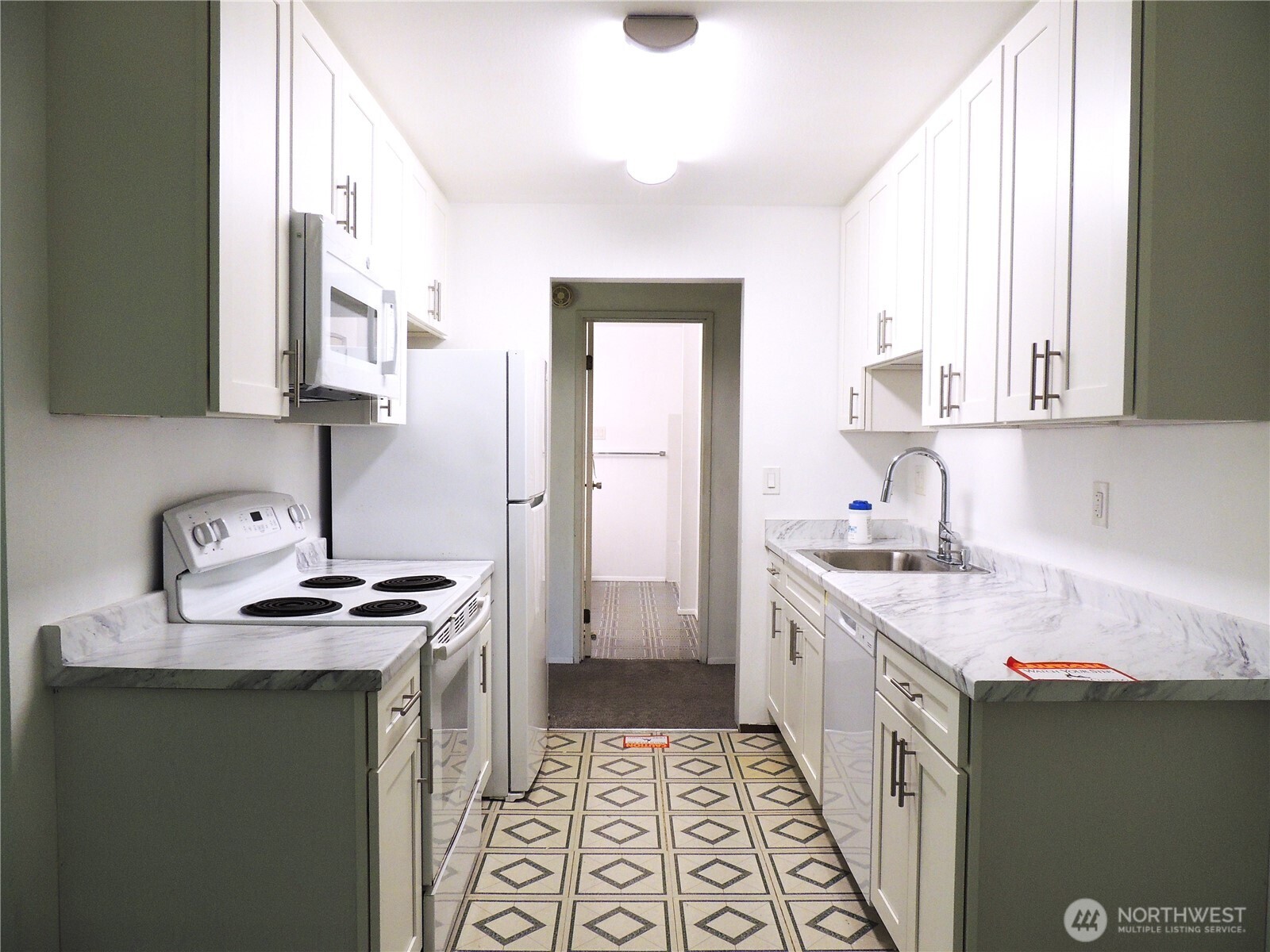 19409 56th Avenue West, Unit 306 Lynnwood, WA 98036 - Photo 6 of 21 a kitchen with a sink stove and cabinets