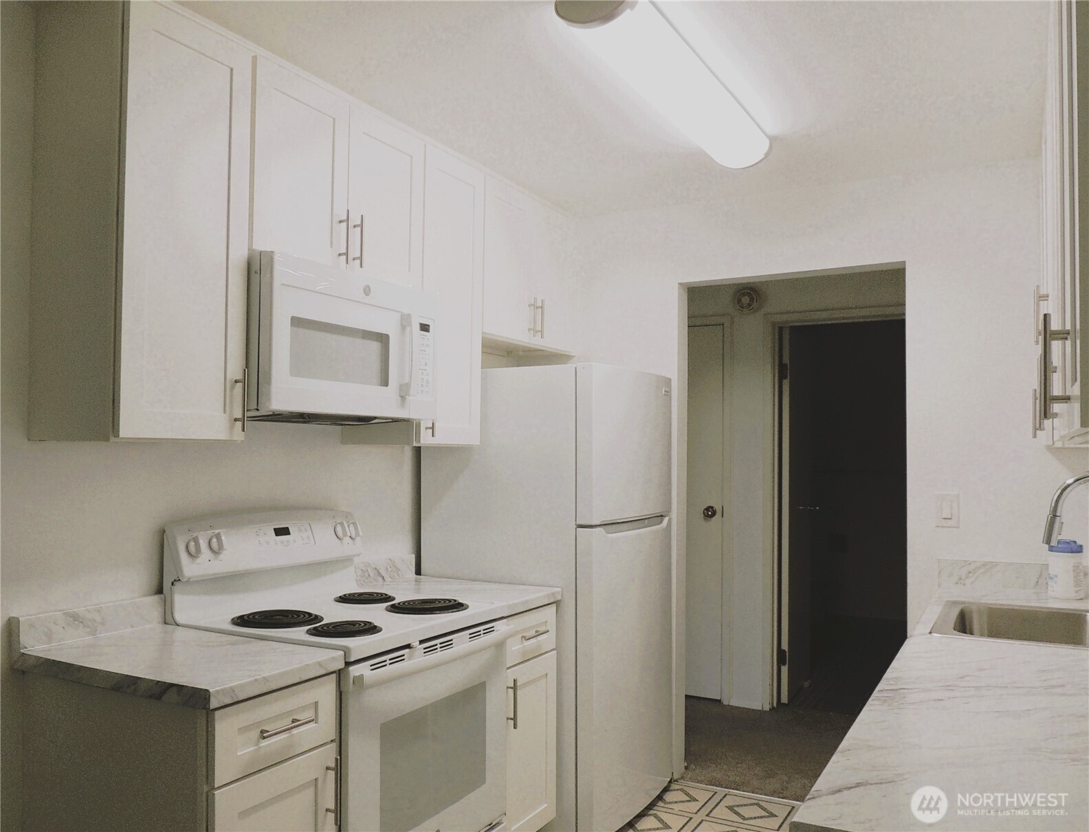 19409 56th Avenue West, Unit 306 Lynnwood, WA 98036 - Photo 7 of 21 a kitchen with white cabinets and white appliances