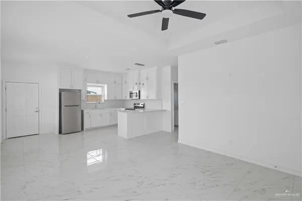 a kitchen with appliances a sink and a refrigerator