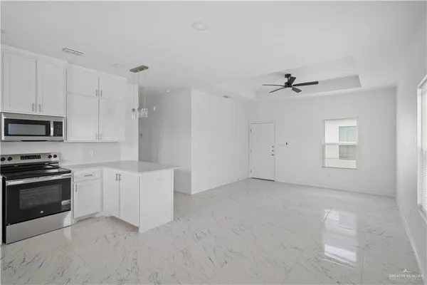 an empty room with a ceiling fan and window