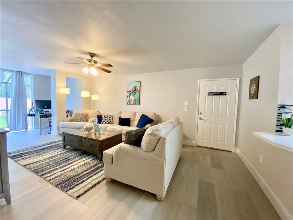 3207 Clint Moore Road, Unit 104 Boca Raton, FL 33496 - Photo 11 of 46 a living room with furniture and a chandelier