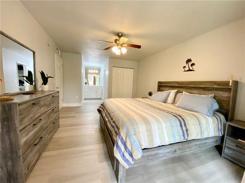 3207 Clint Moore Road, Unit 104 Boca Raton, FL 33496 - Photo 18 of 46 a spacious bedroom with a bed and a chandelier
